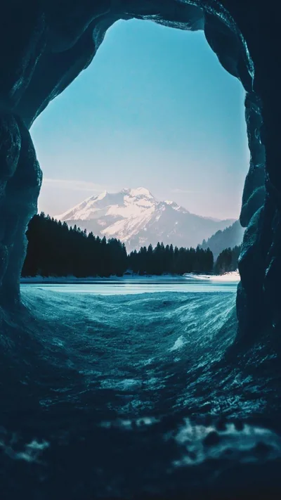 Snowy Peak Framed by an Ice Cave HD Phone Wallpaper