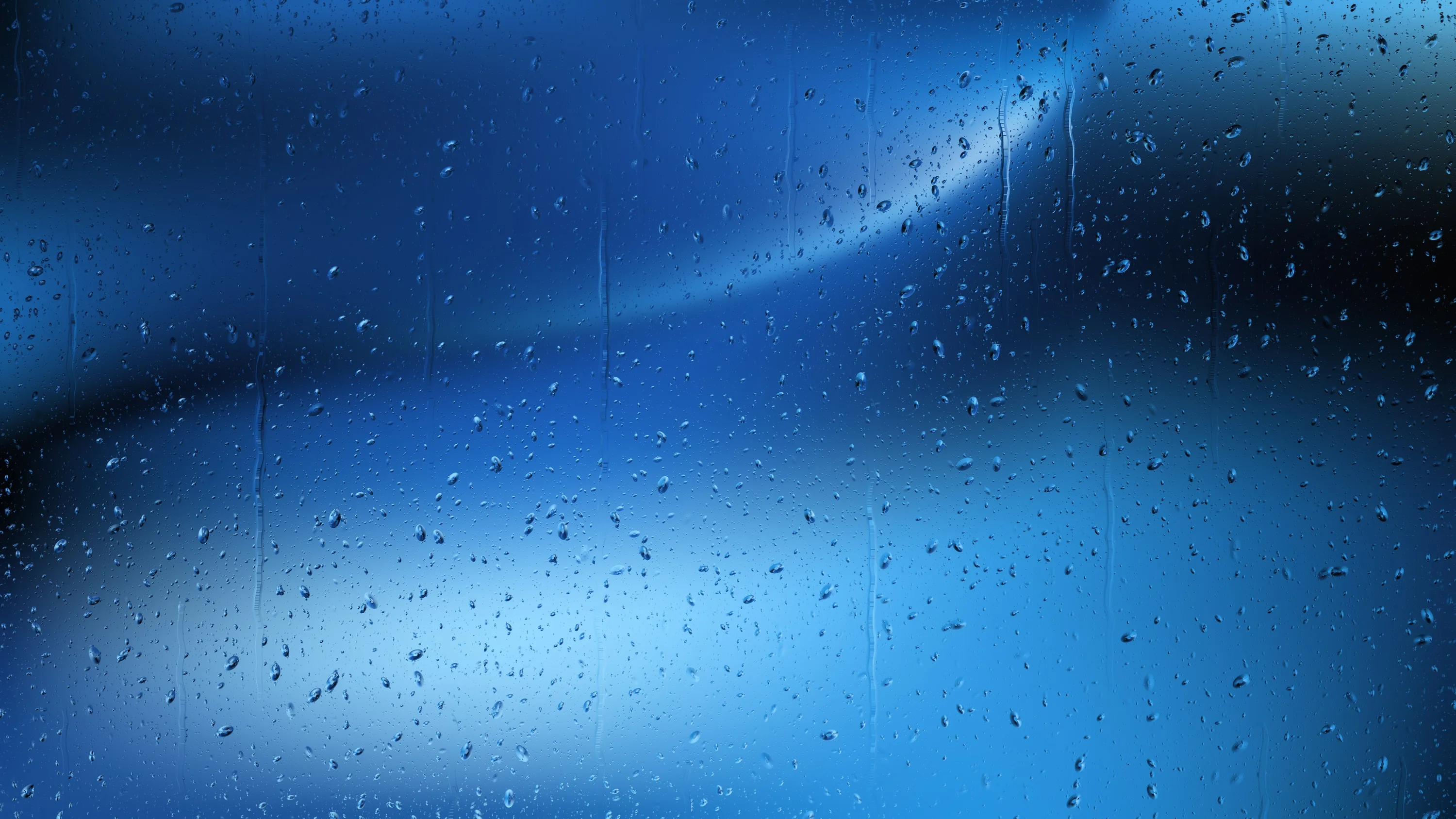 Fine condensation drops cover a pane lit electric blue from the lower left, while the top right corner falls away to black for a clean status bar.