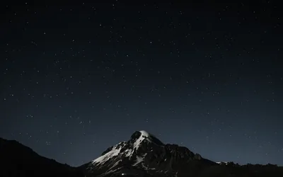 The night sky with stars above a mountain MacBook Air Wallpaper