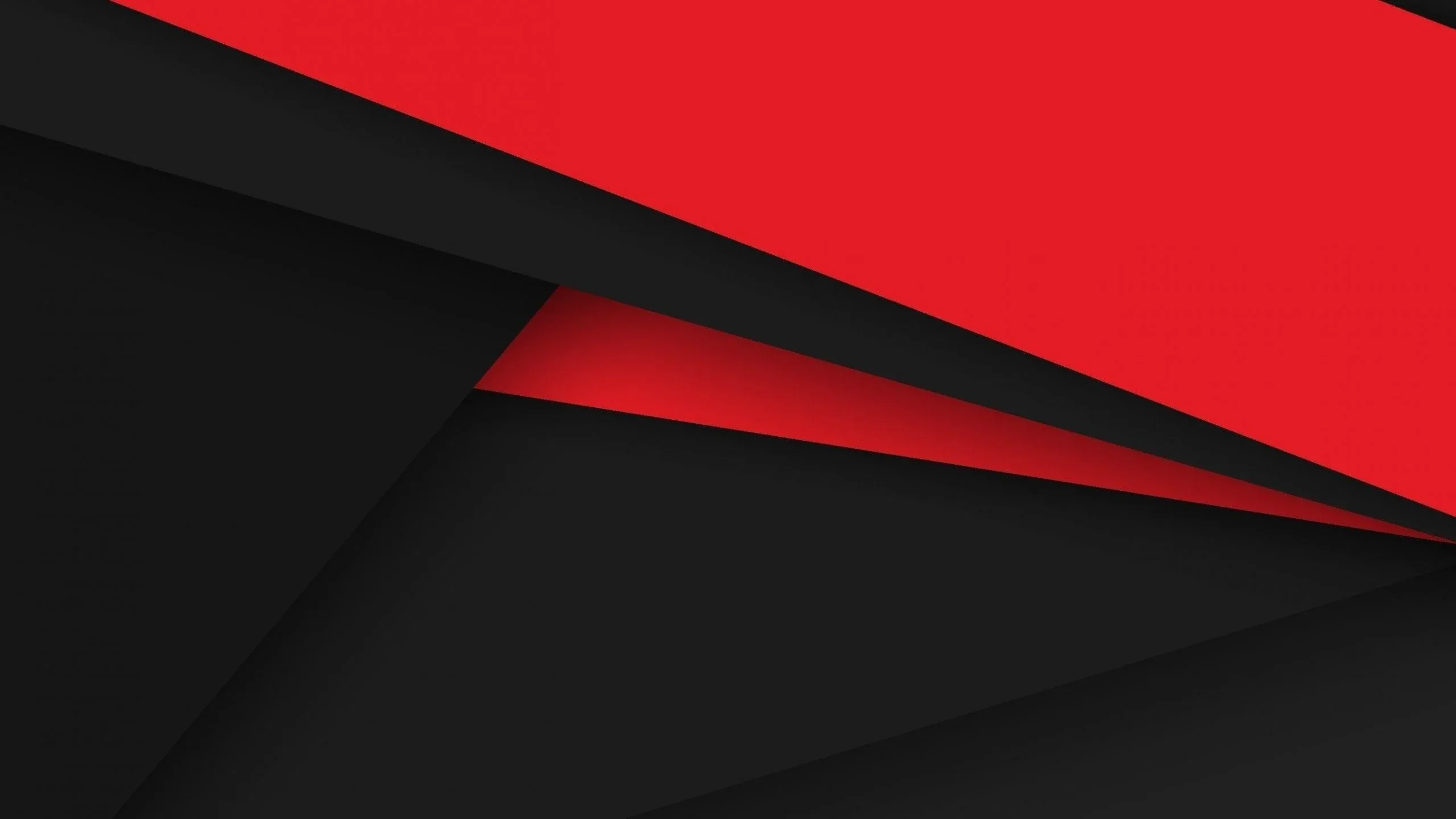 Flat sheets of black and charcoal overlap in soft diagonals with one wide red band cutting across the top corner.