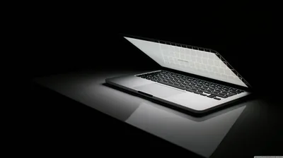Laptop Glowing on a Dark Surface HD Wallpaper
