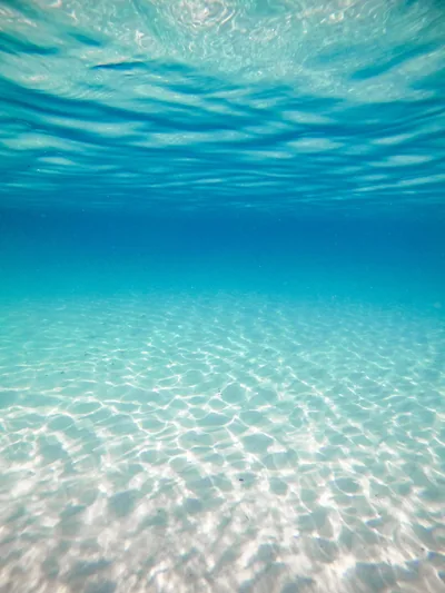Underwater View of a Turquoise Seabed HD Phone Wallpaper