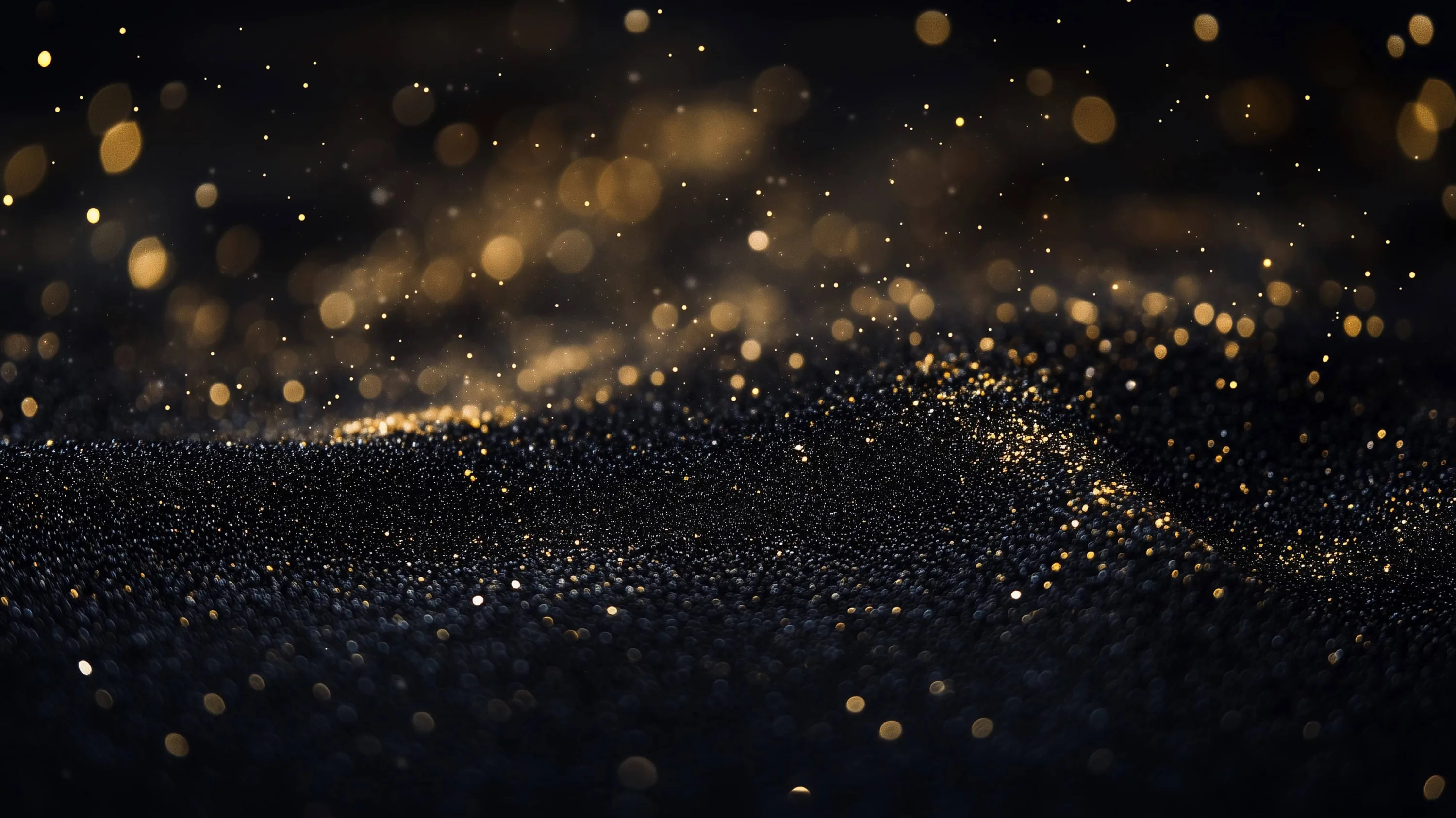 Golden particles drift upward from a midnight-blue glitter mound, large soft bokeh circles gathering toward the upper-left, the ridge below staying in sharp focus.