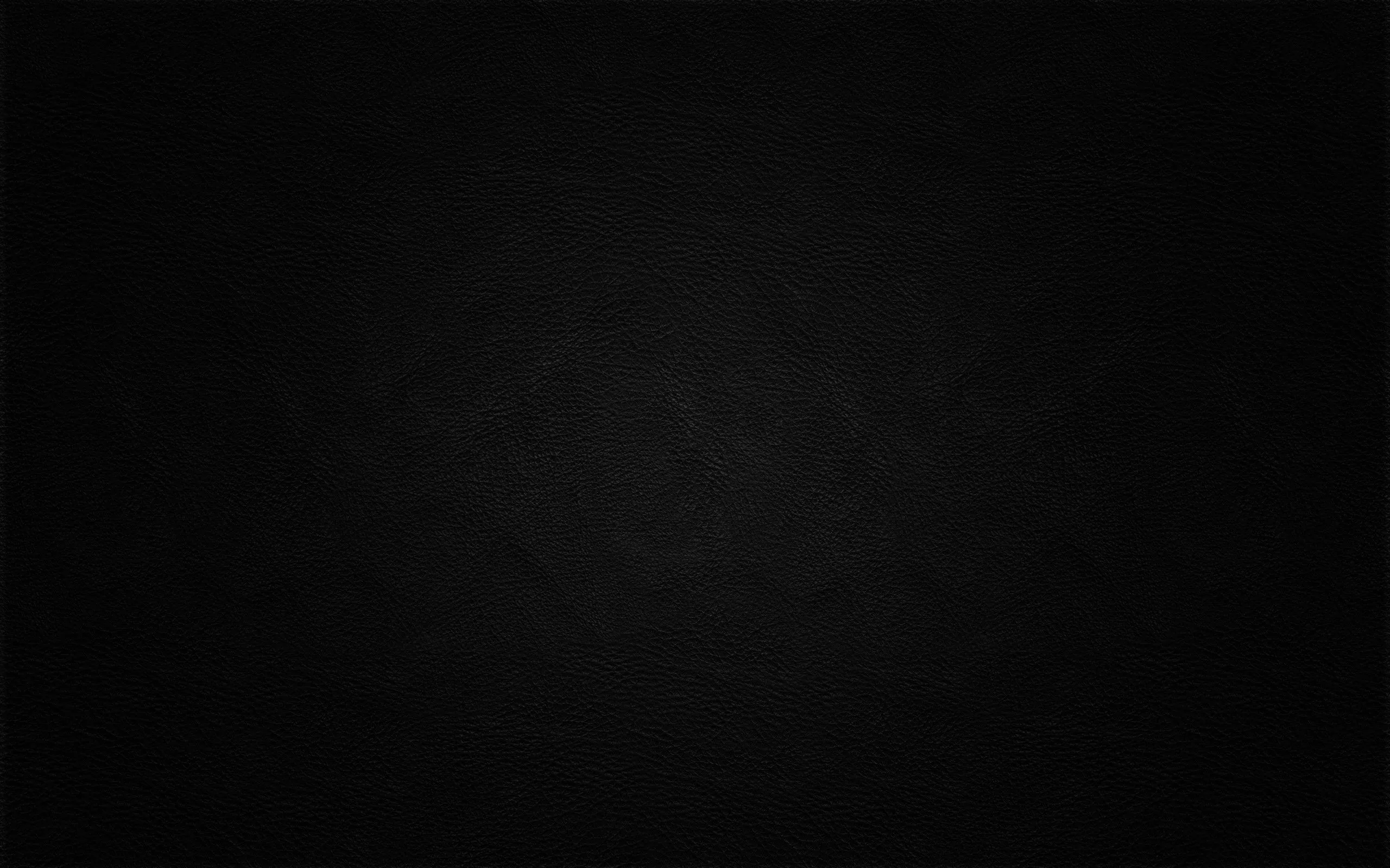 A matte black slate with faint chalk smudges spread across the middle and a heavy vignette pulling the edges darker.