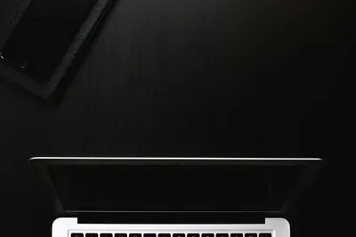 Laptop and Phone on a Black Desk HD Wallpaper