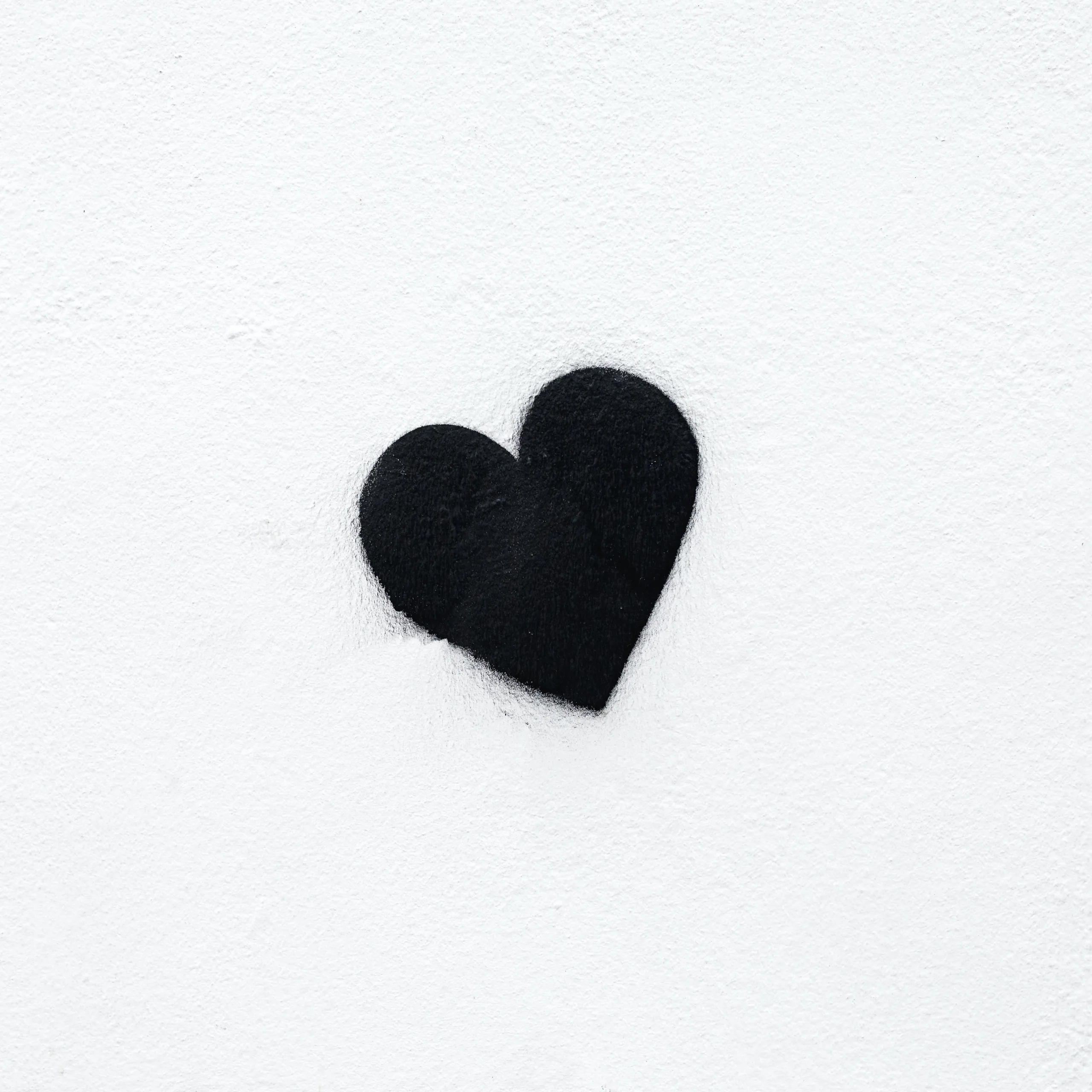 A fuzzy fabric heart sits a little left of centre on an off-white square, its faint shadow falling straight down, wide empty margins ready for icons.