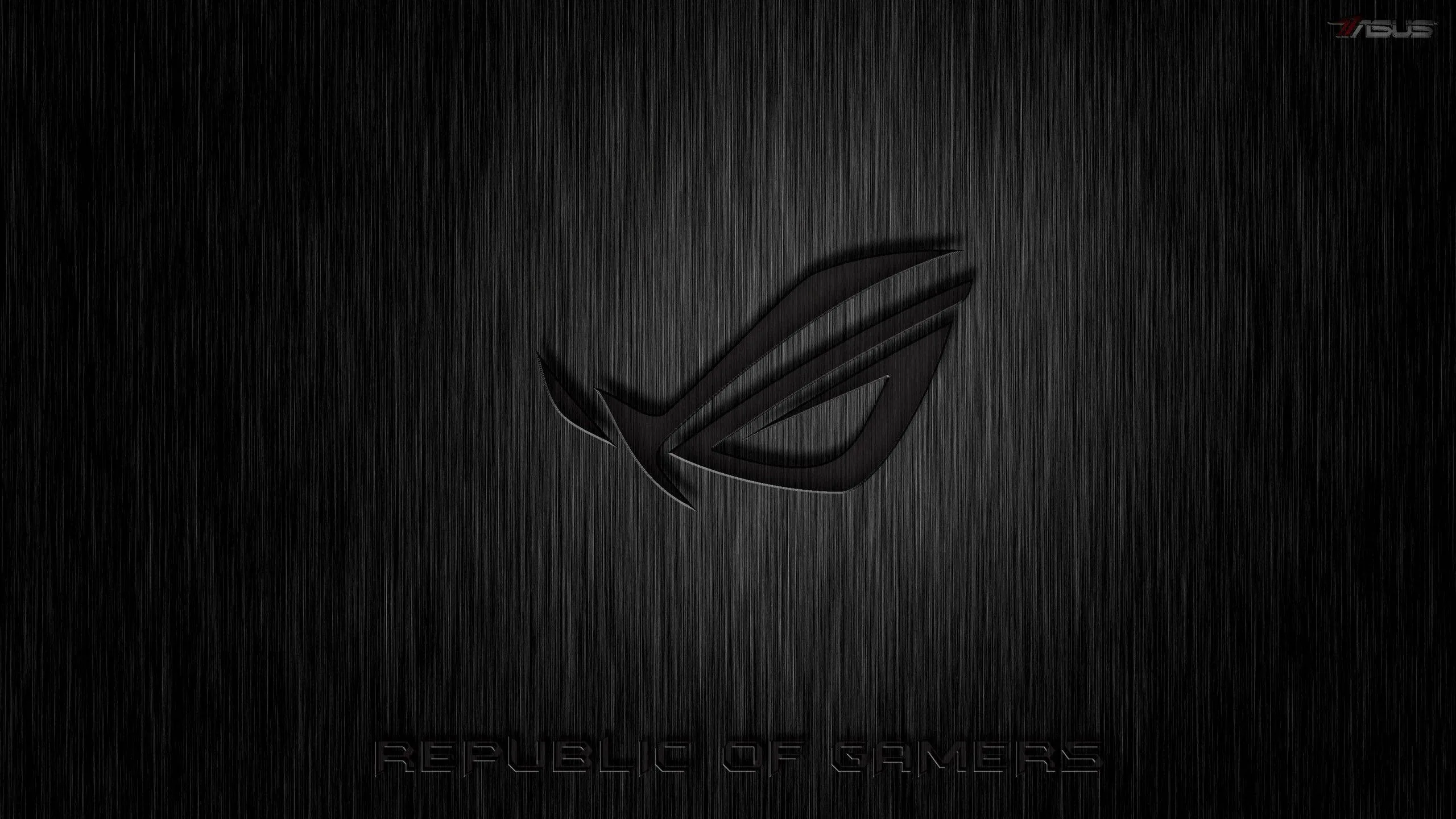 The ROG eye glows faintly through streaks of rain on grey metal, the Republic of Gamers lettering set low along the bottom.