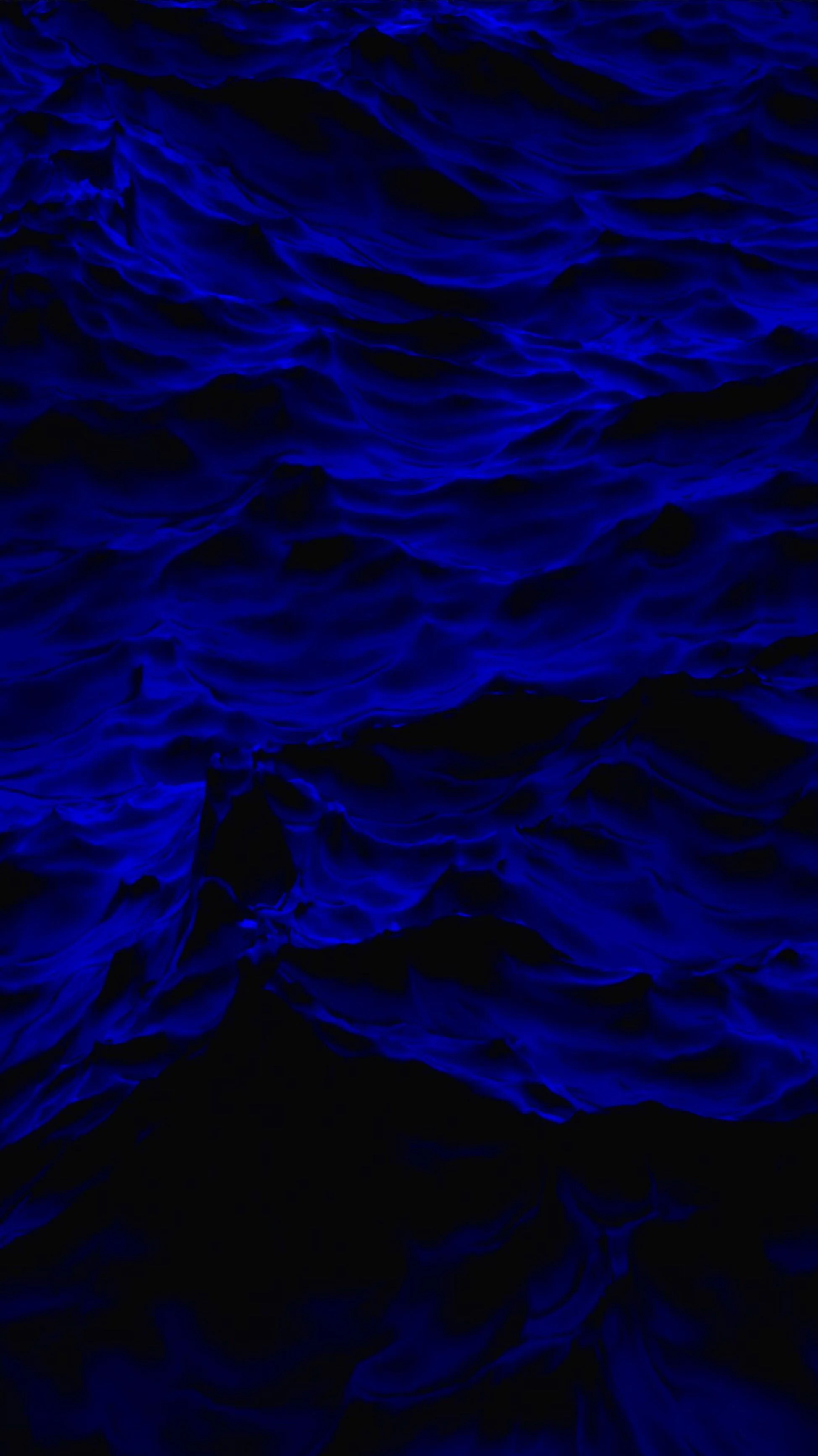 Rows of ultramarine wave crests glow across the top half, then dissolve downward into flat black; the bottom of the screen stays true black on OLED.