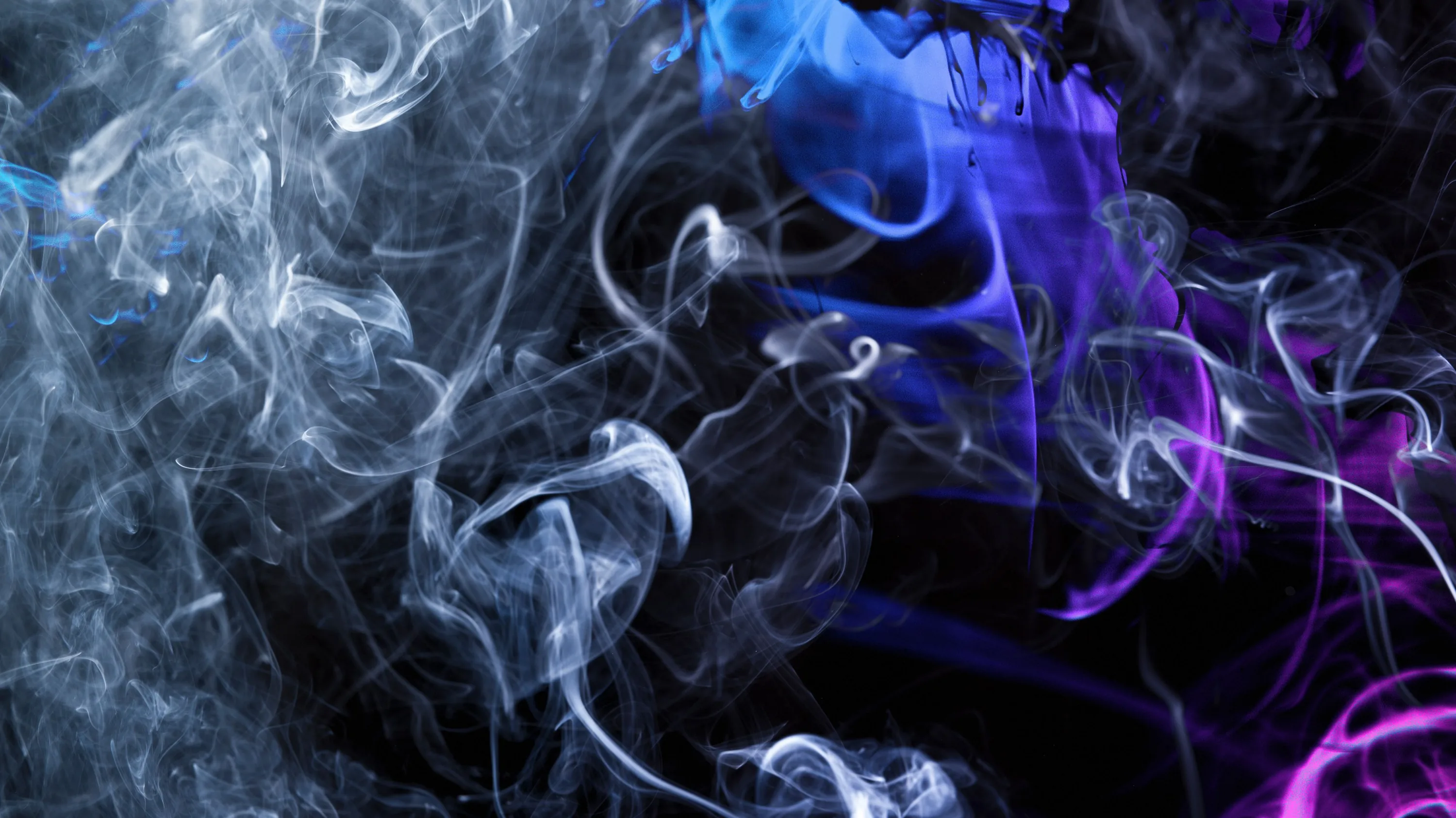 Grey wisps on the left give way to smoke lit electric blue and violet on the right, as if coloured lights sit just outside the frame.