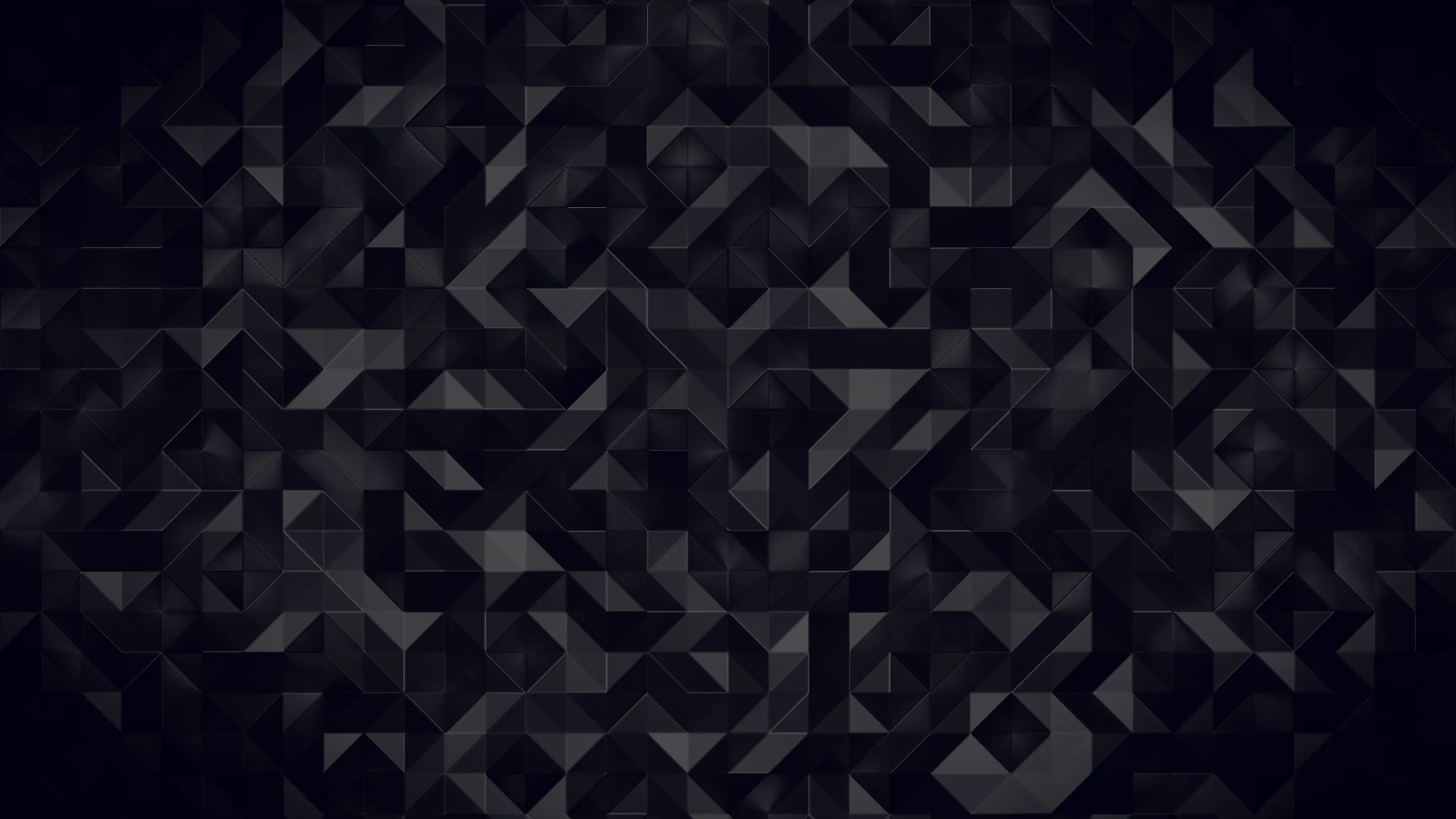Angular facets in charcoal and near-black tile the surface, each one catching light differently so shapes surface and sink.
