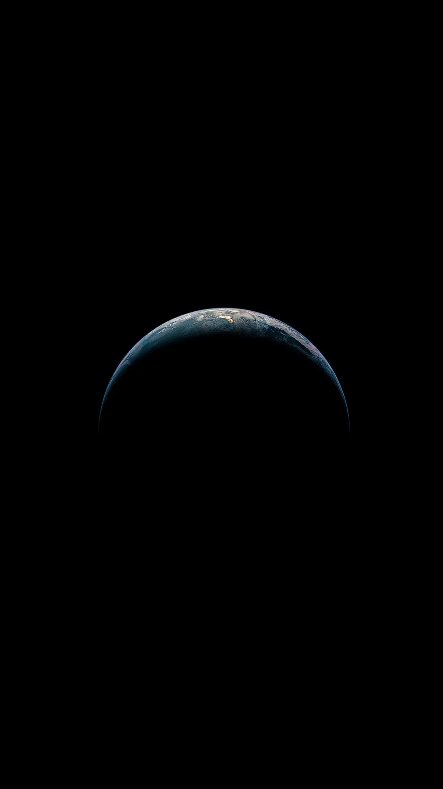 A thin lit crescent curves along the top of the planet with cloud detail just visible, the rest of the globe lost in shadow.