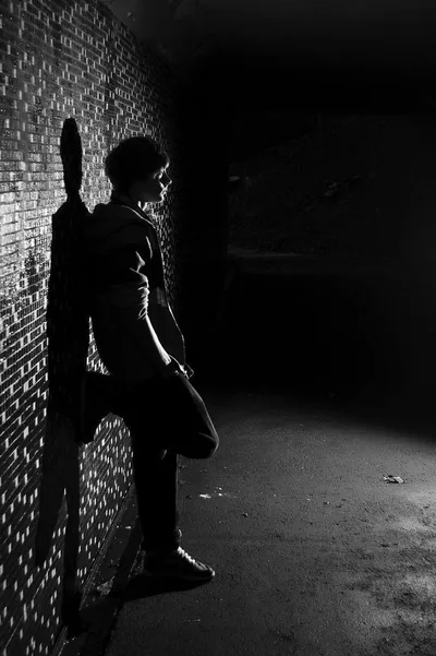 Boy Leaning on a Brick Wall in an Alley HD Phone Wallpaper