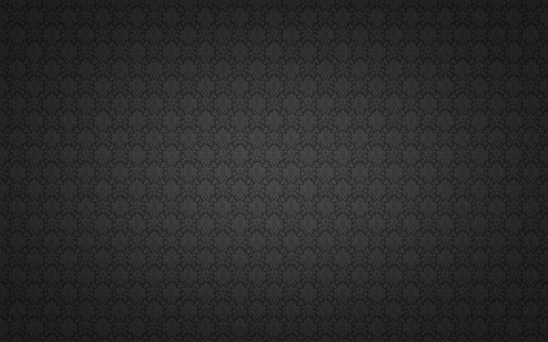 A small floral motif tiles edge to edge across dark grey, brightest through the middle band and vignetted down at all four corners.