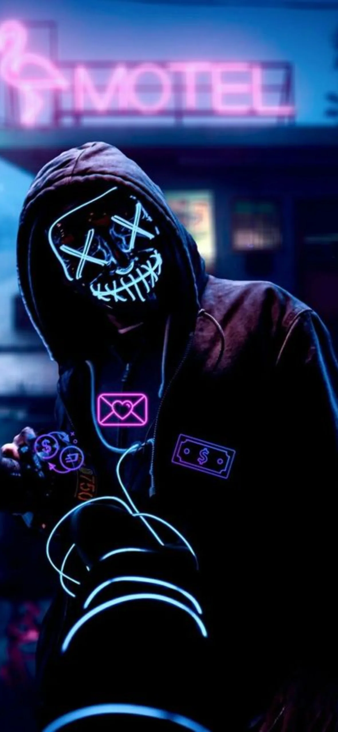 A hooded figure in a purple LED stitch-mask stands under a pink motel sign, neon signs blurred into bokeh along the street.