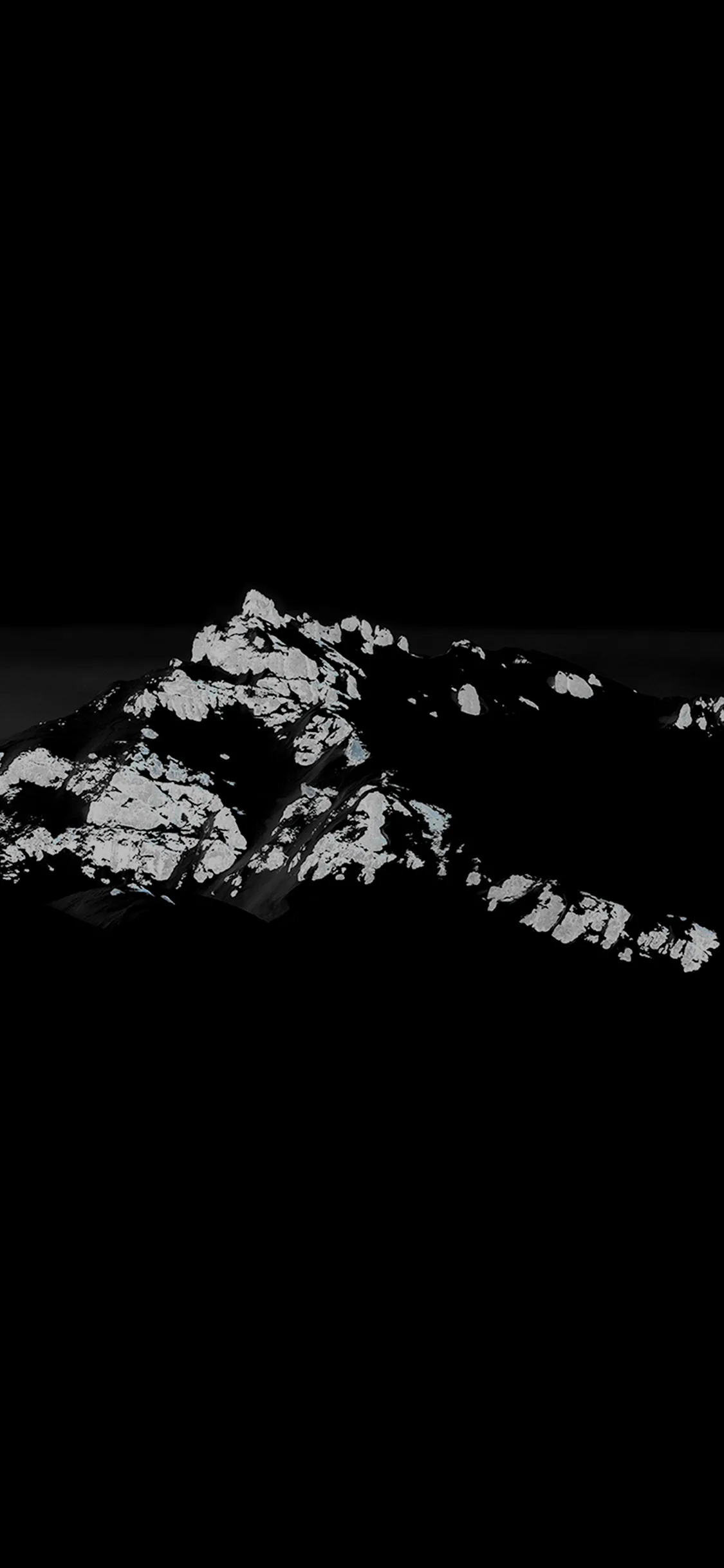 Only the sunlit snowfields of a mountainside catch the light here, the rock itself dissolving into black, leaving the entire top half dark for the clock.