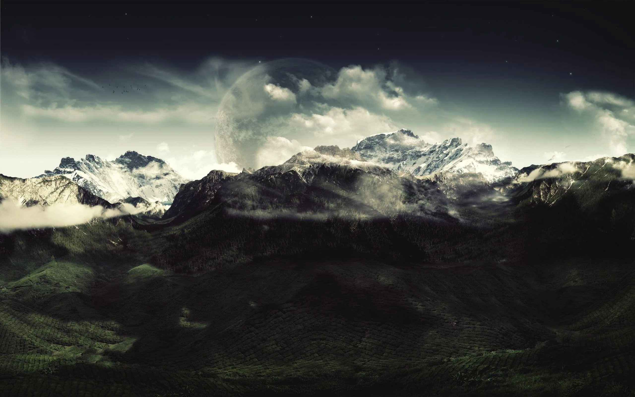 A pale planet climbs behind cloud between snow-capped summits, faint stars in the black upper corners and the forested foothills sinking into shadow below.