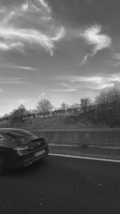 Black Car Driving on Highway in B&W