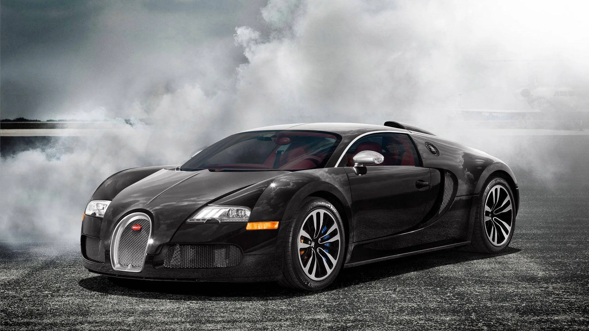The Veyron sits front-quarter on with white smoke boiling across the ground behind it, chrome grille and door blade catching the low grey light.