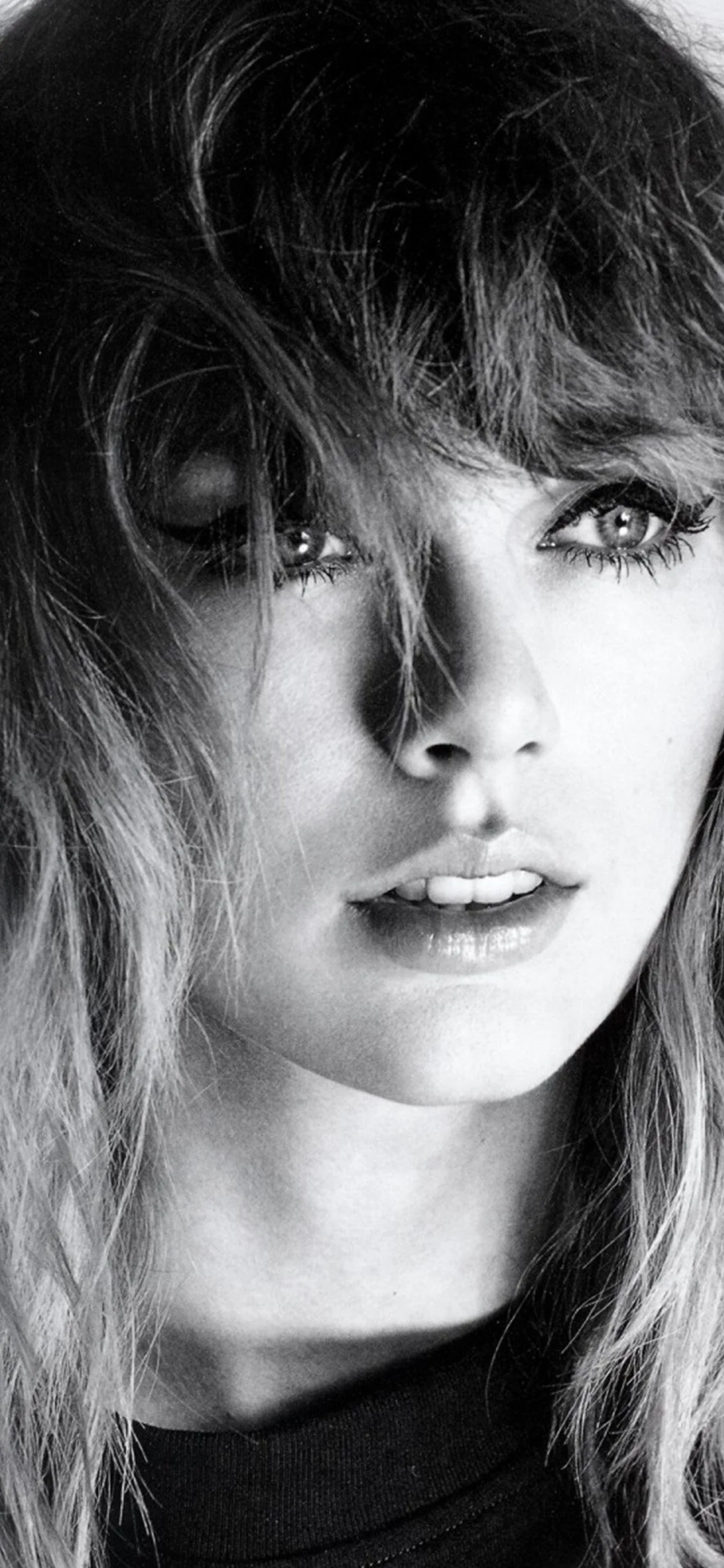 A tight black and white crop of a woman's face, strands of hair crossing one eye; the crop is so tight there is little room left for widgets.