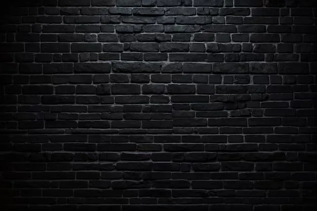 Wide courses of black brick with light spilling down from overhead, the mortar lines still readable through the middle before the corners go dark.
