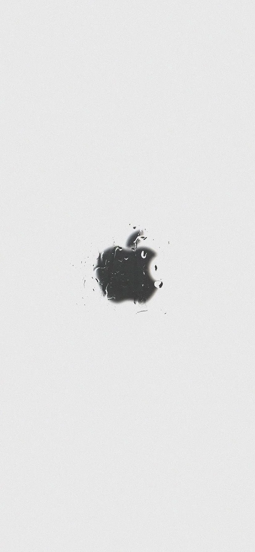A black Apple mark in rough splatter texture sits just left of centre on a pale grey field, every other part of the frame empty.