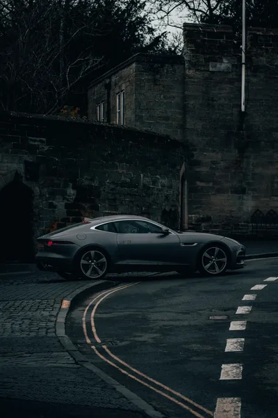 Jaguar F-Type on a Curved Stone-Walled Road HD Phone Wallpaper
