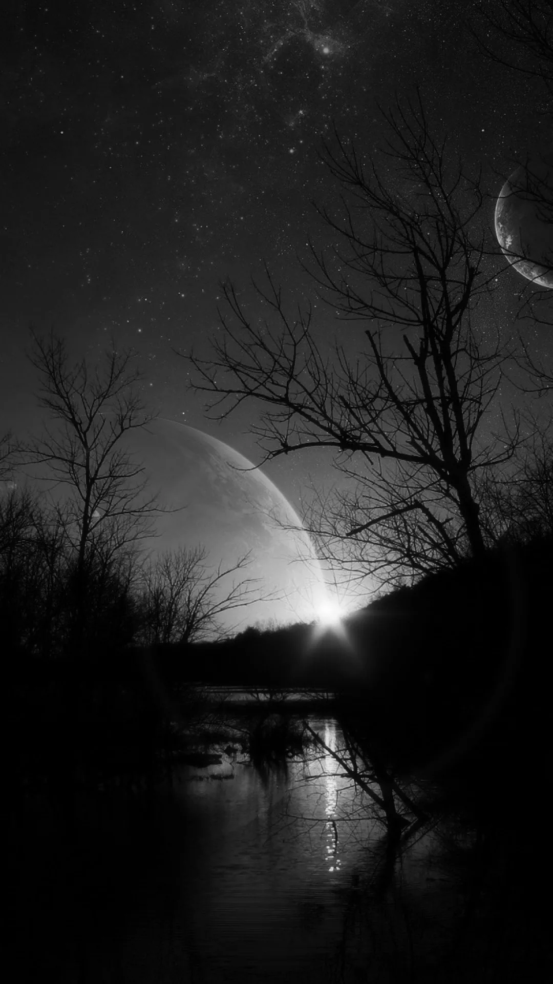 Two moons hang in a starry monochrome sky above leafless branches, their light streaking down a still river below.