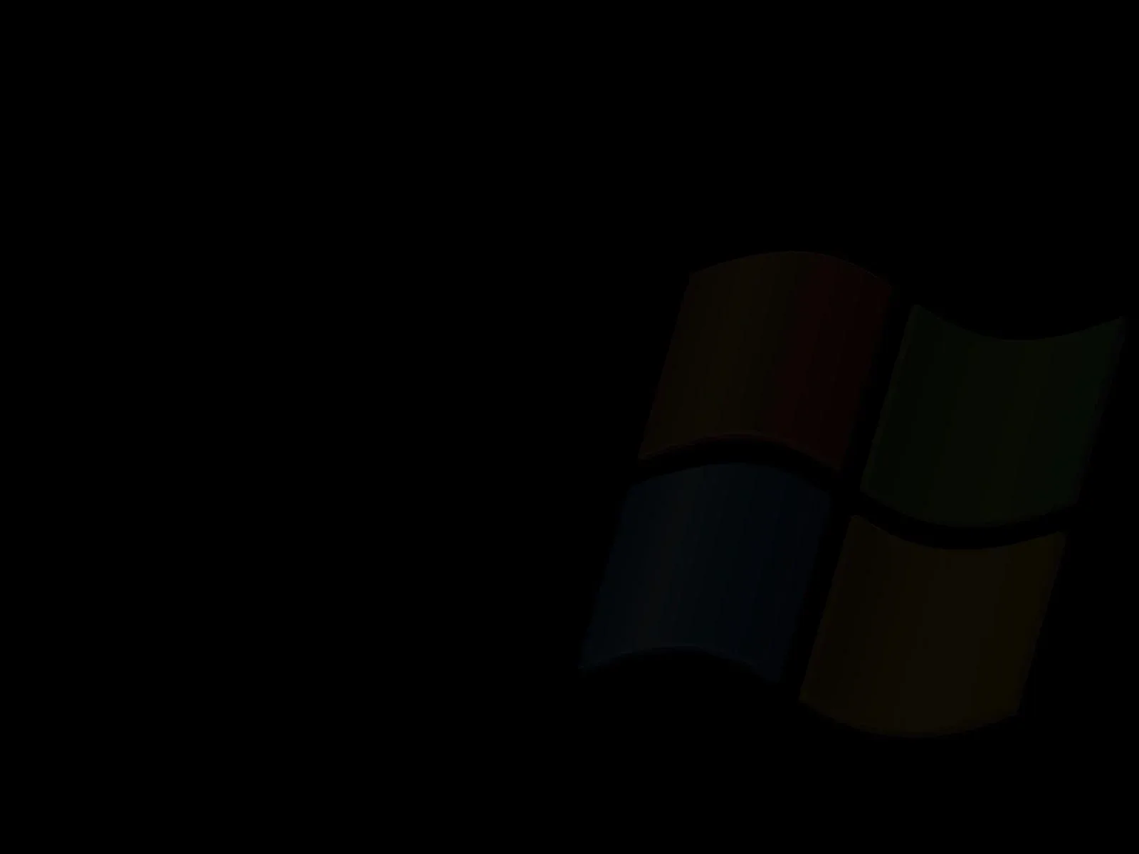 The four-pane Windows flag sits right of centre, its red, green, blue and yellow dimmed almost to nothing against a completely black background.