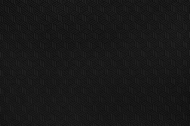 Rows of tiny isometric cubes cover an almost solid black field, the 3D effect visible only when the light catches the top face of each block.