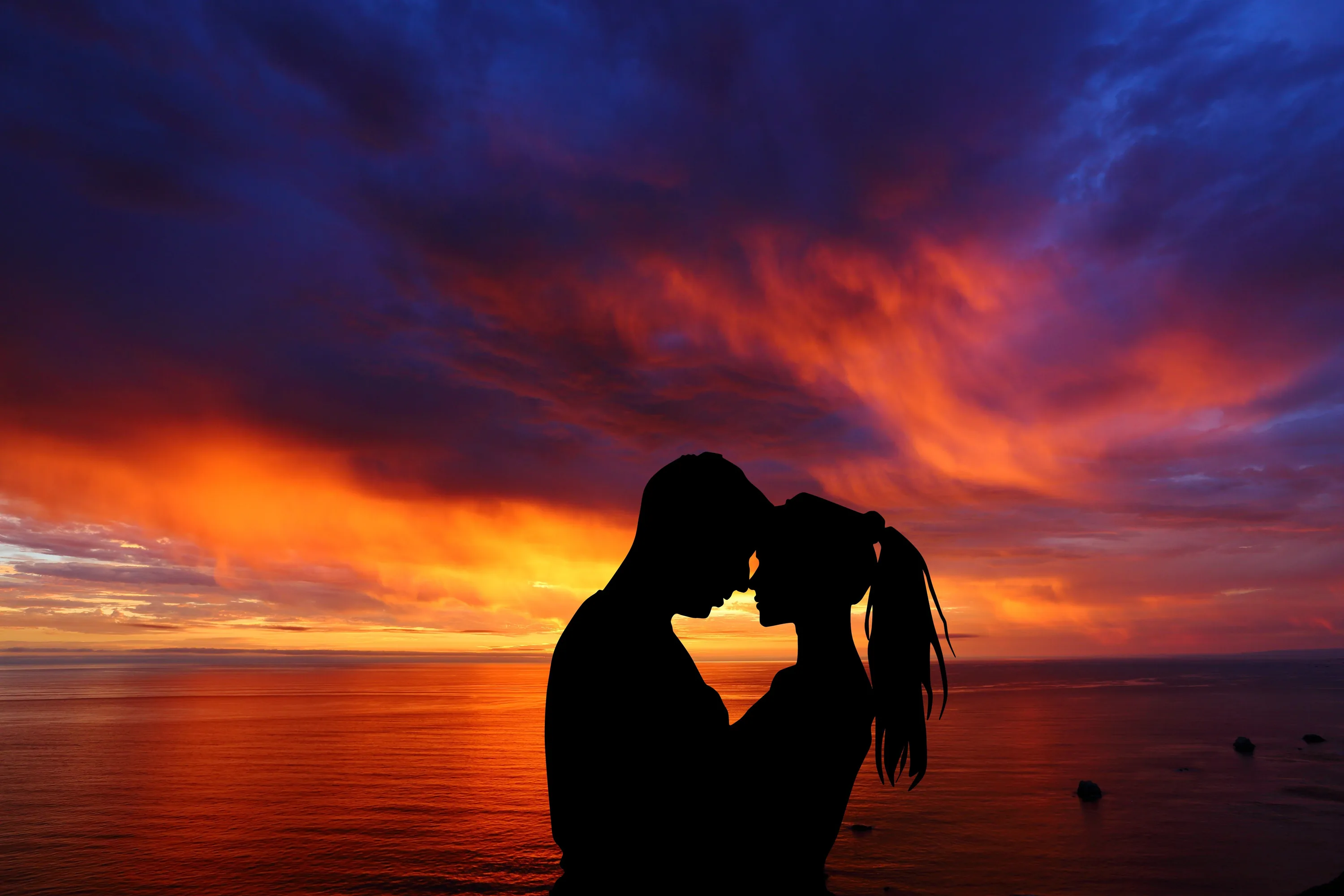 Orange and violet storm clouds blaze over a calm sea while the pair press foreheads together low in the frame, her ponytail edged by the horizon light.