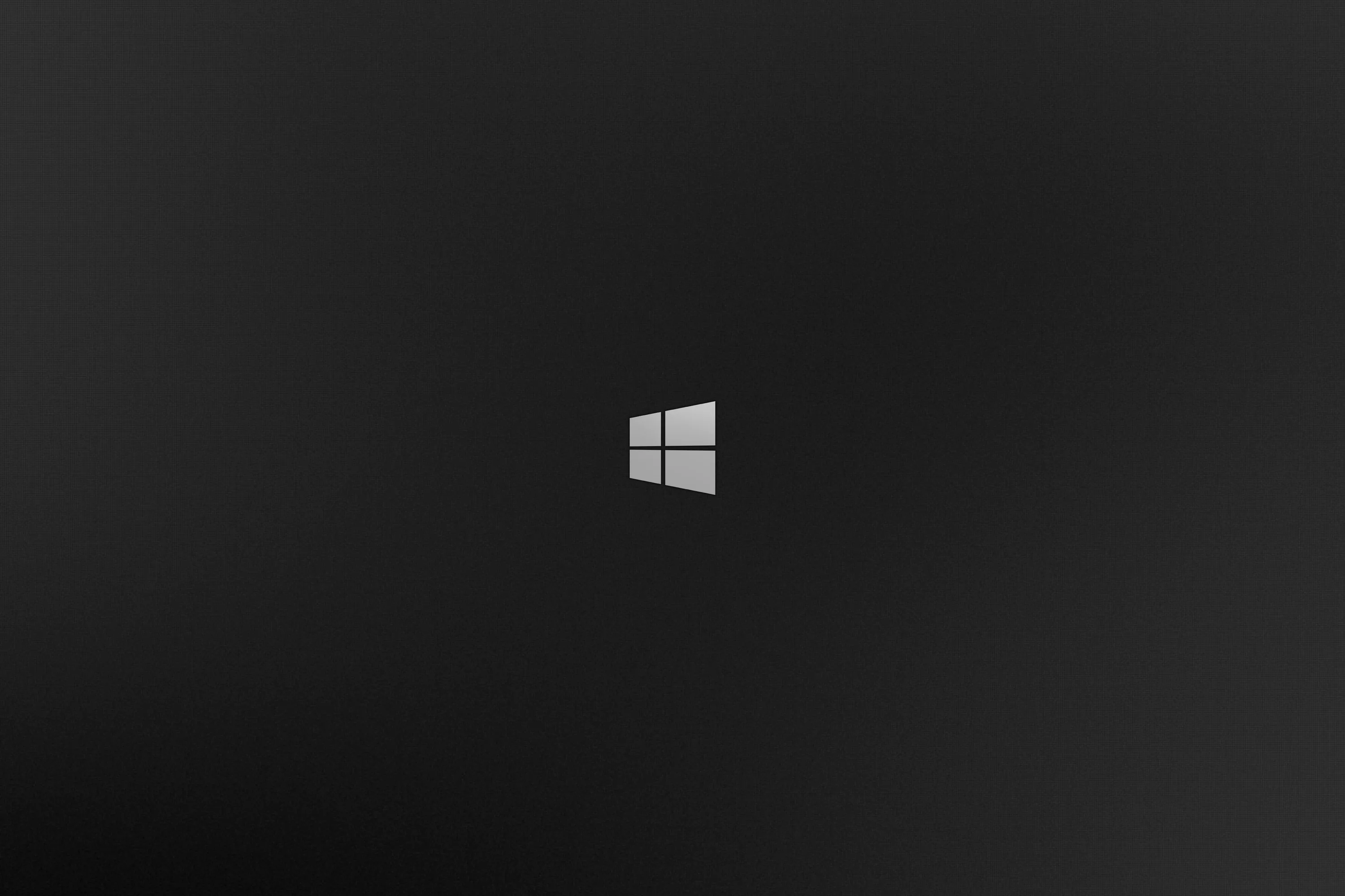 The four-pane Windows 8 mark sits small and centred on a charcoal gradient, the corners falling away to near black.