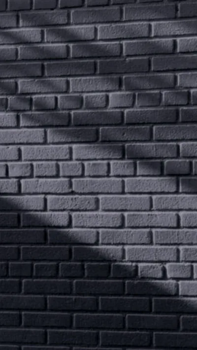 Shadow Falling Across a Grey Brick Wall HD Phone Wallpaper