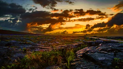 beautiful field plain green grass stones rocks sunset black clouds dark wallpaper mount