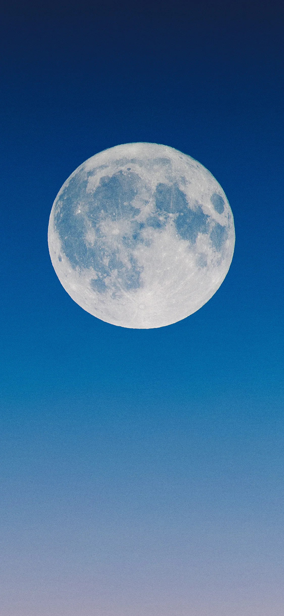 A pale full moon floats in a clean gradient of daytime blue with no clouds anywhere, leaving the entire lower half clear for widgets.