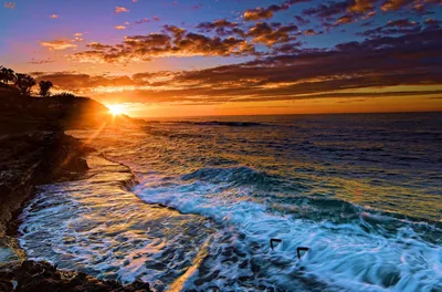 Sun Flaring Over a Rocky Surf Break HD Wallpaper