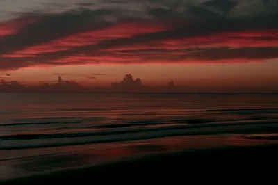 Dark Red Clouds Over a Black Shore HD Wallpaper