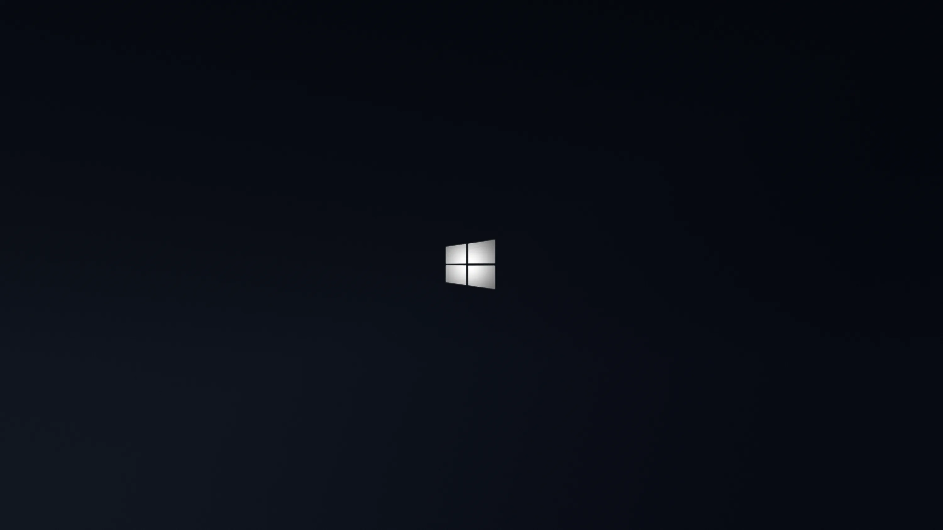 A small bright Windows logo floats just above centre in a deep navy-black space with a broad soft shadow filling the left side.