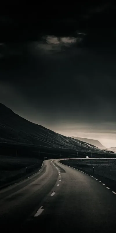 Winding Road Under a Storm Sky HD Phone Wallpaper