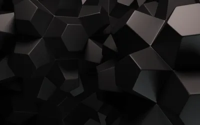 Matte black hexagons and shards jut out at different depths, lit softly from the upper left so each facet catches its own grey edge.