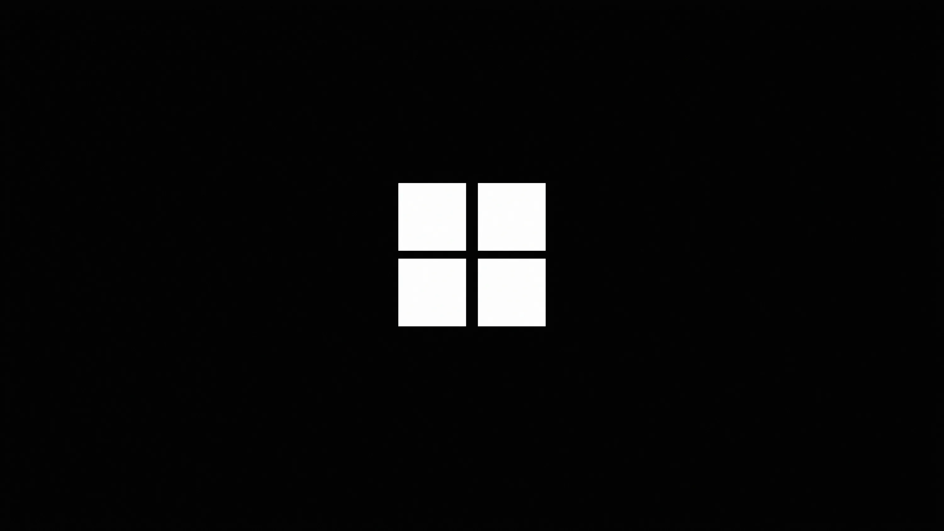 The four-pane Windows 11 logo sits small and dead centre in white, everything around it left at full black.