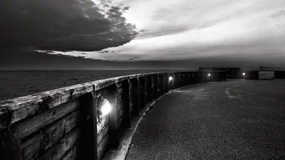 Curved Sea Wall at Dusk with Lamps HD Wallpaper