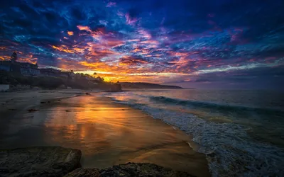 Storm Clouds Glowing Over a Beach Cove HD Wallpaper