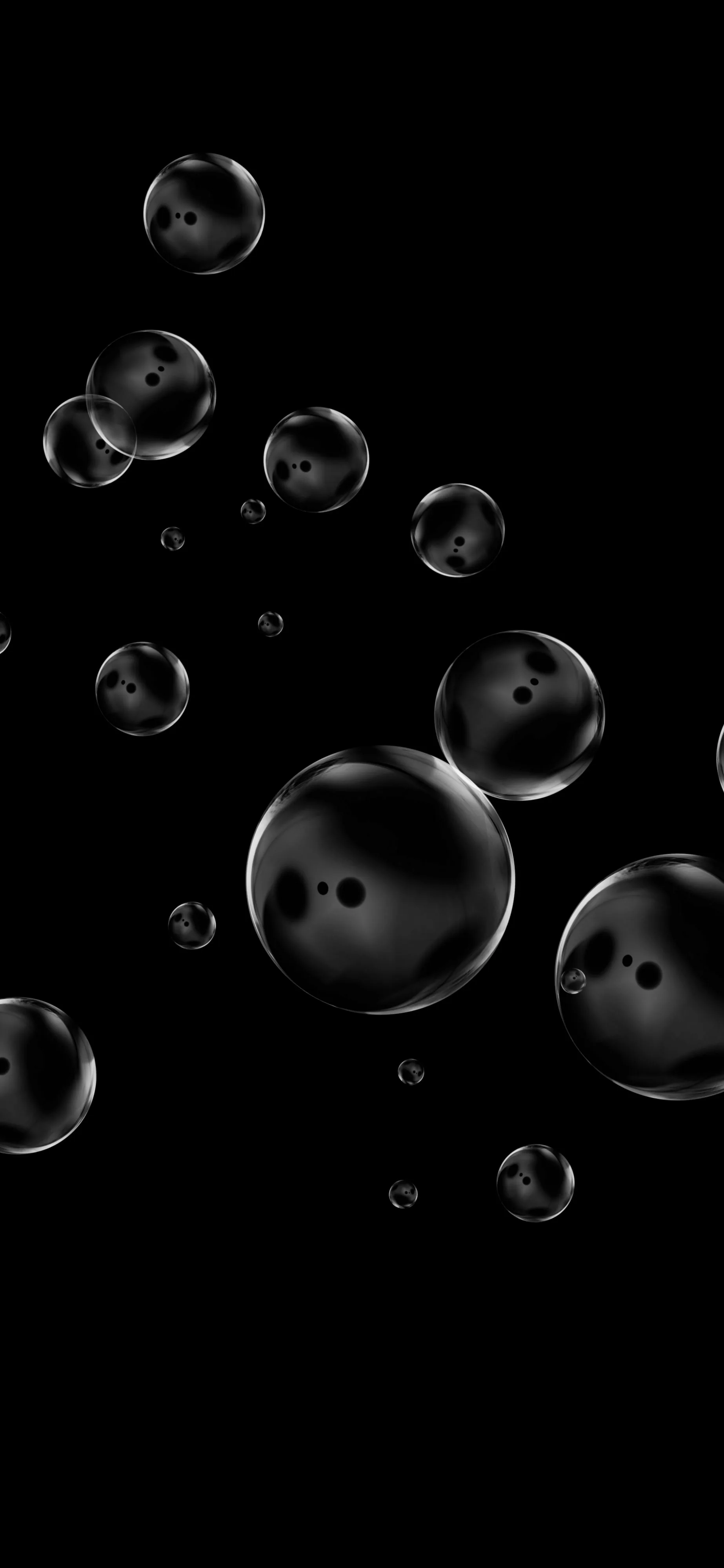 Soap bubbles of different sizes drift up the frame against solid black, each one ringed with a thin highlight and a pair of bright specular dots.