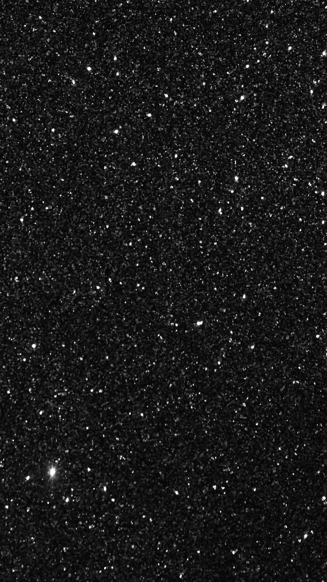 Extremely fine specks over a charcoal ground, one brighter star-like fleck low on the left, the top band dark enough to keep a clock readable.