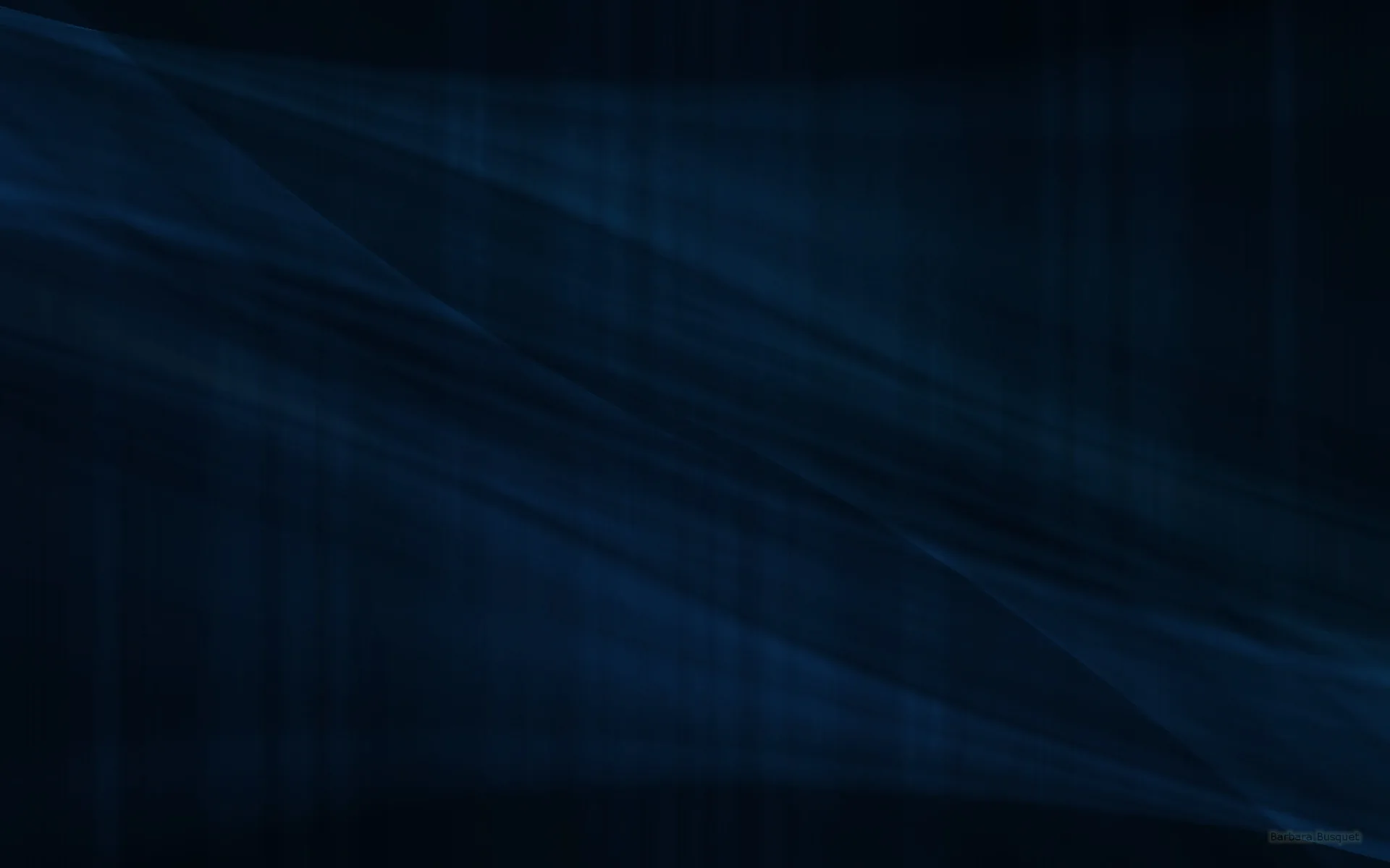 Broad diagonal folds cross a deep navy surface, so gently lit that the texture only shows where the light grazes the ridges.