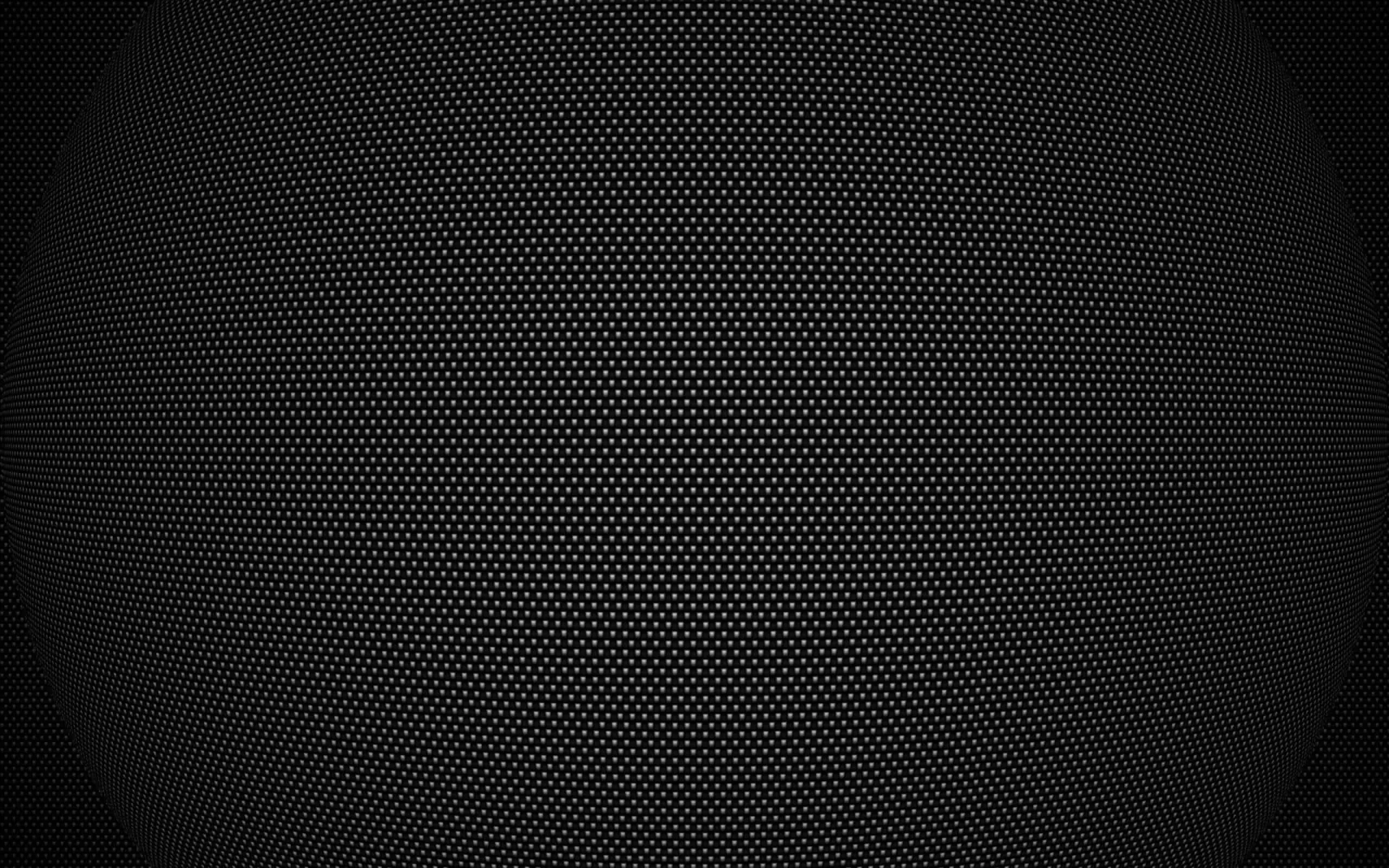 Thousands of tiny perforations in an even grid, an oval glow lifting the centre while every edge sinks to black — calm enough behind app icons.