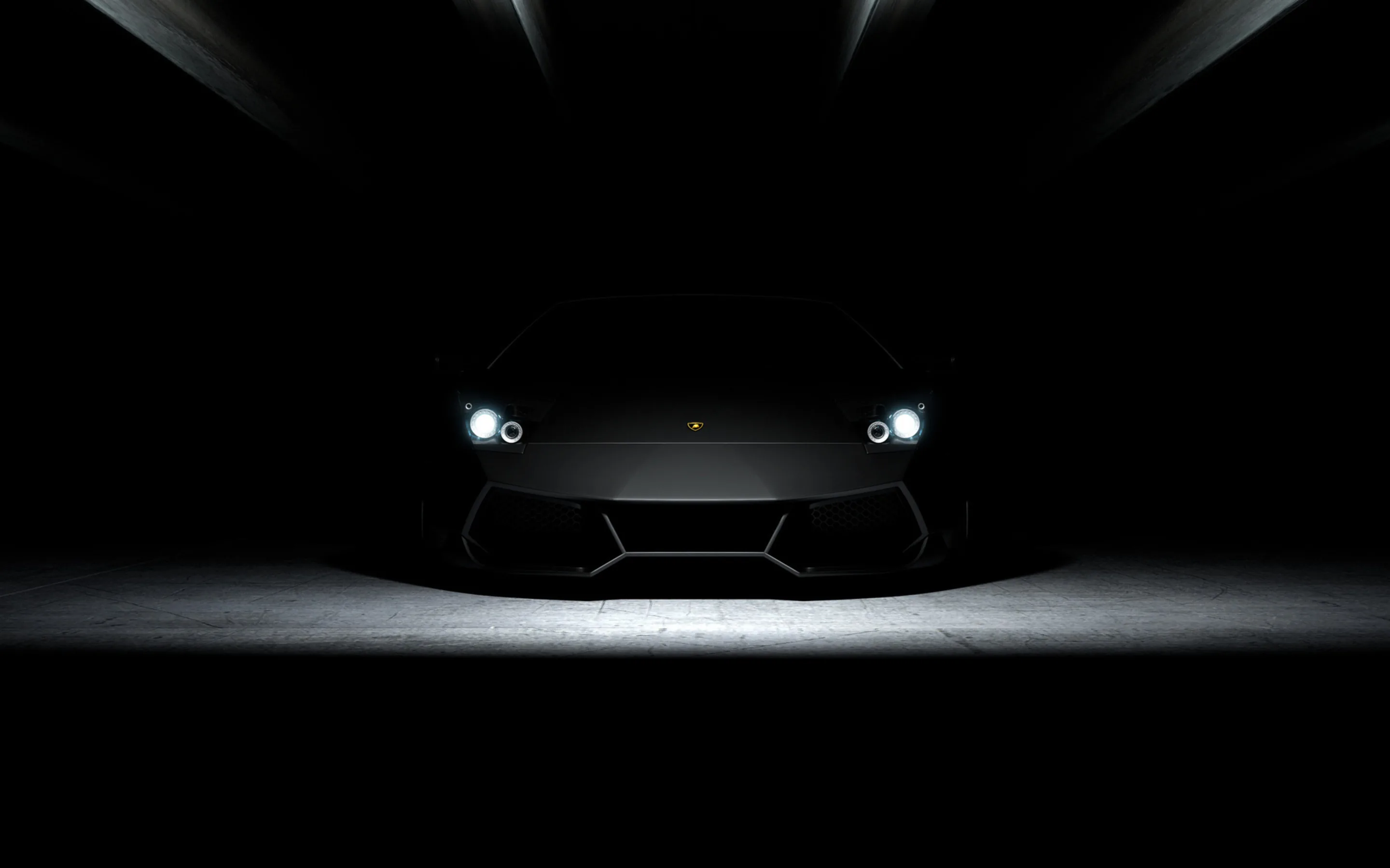 Only two lit headlights and a small pool of floor light mark out a wedge-shaped supercar, the rest of the frame falling to near-total black for OLED.