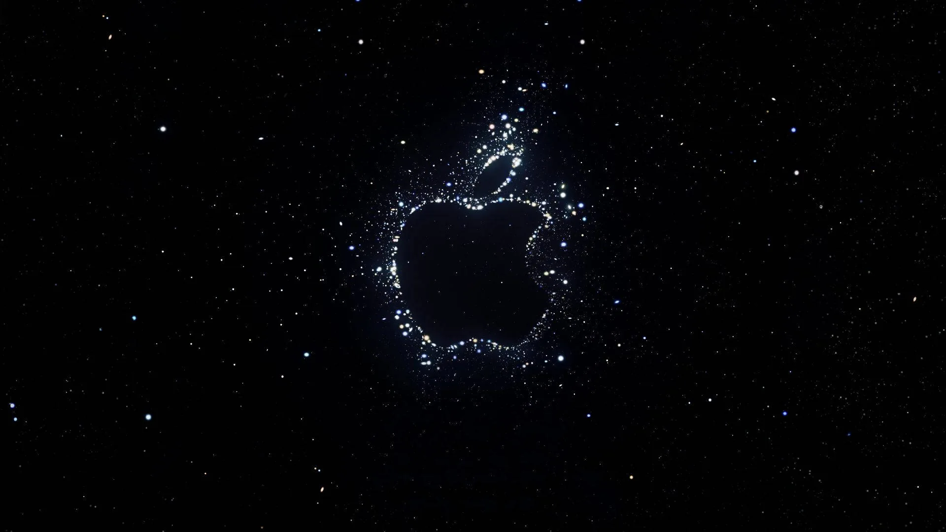 The Apple mark drawn out of scattered white specks against a deep black sky, the surrounding dots thinning into empty space.