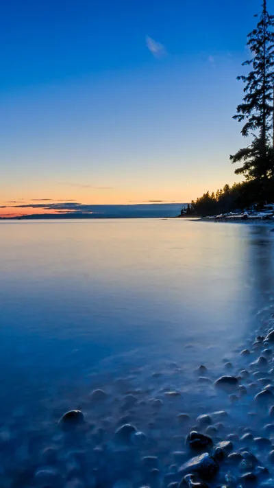 Blue Sunset Over a Pebble Shoreline HD Phone Wallpaper