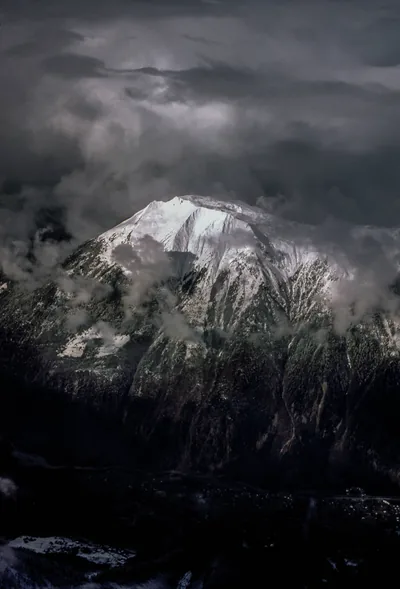 Snow-Capped Peak in Storm Clouds HD Phone Wallpaper